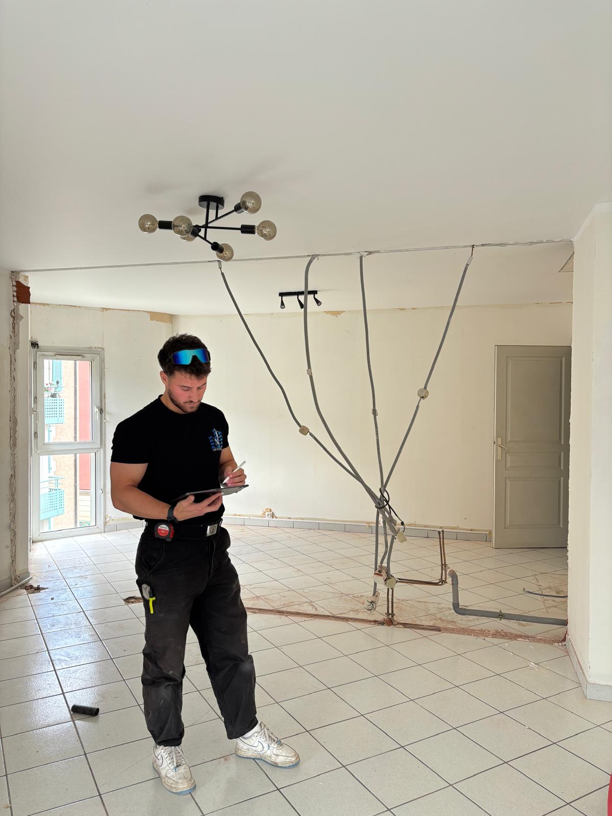 Nicolas Pereira, fondateur de NHP Construction, tablette en main sur un chantier de rénovation intérieure